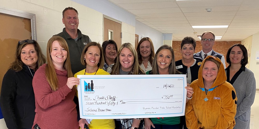 Teachers holding large check with foundation members.